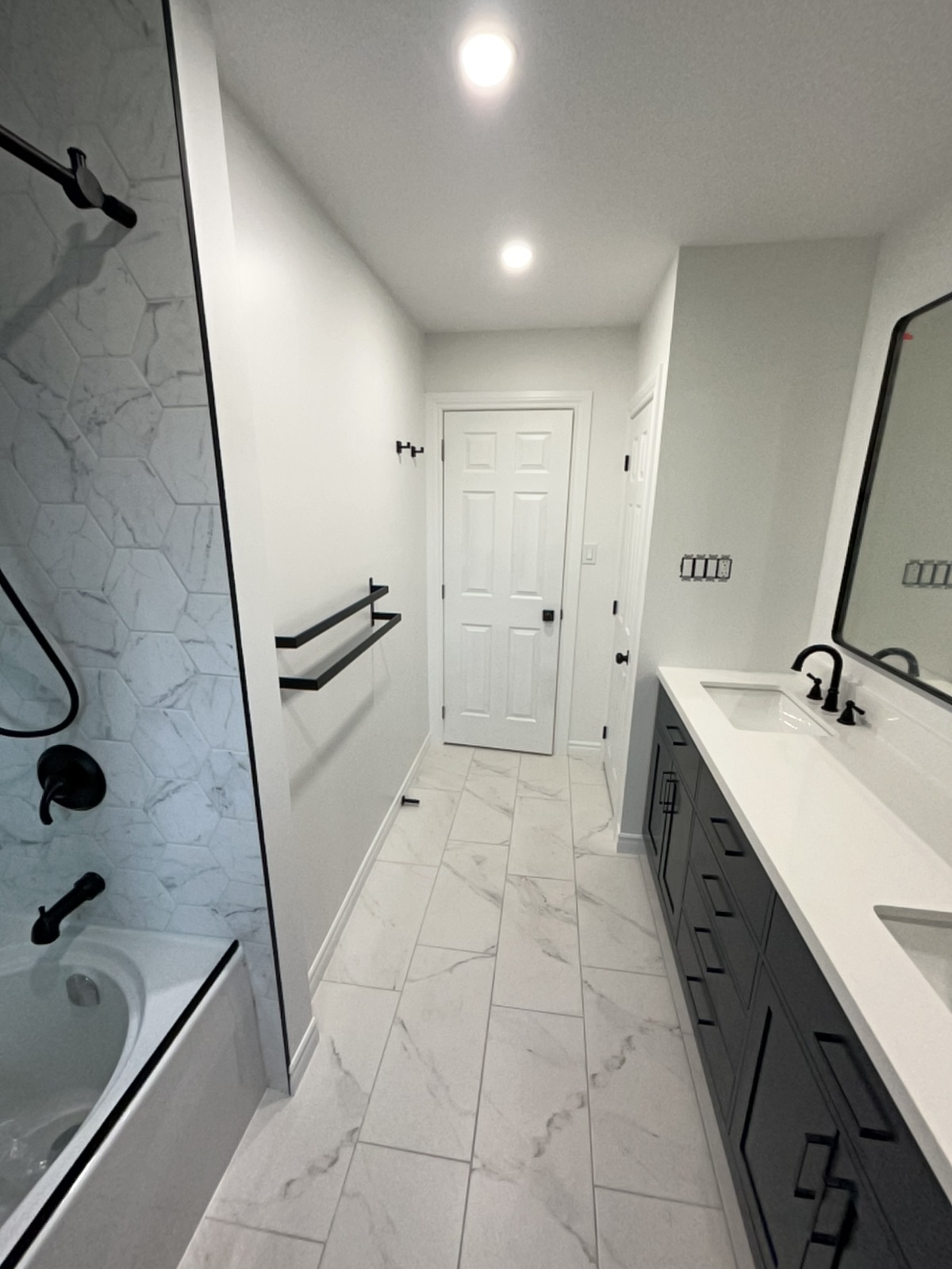 a bathroom shower/tub combo and double sink